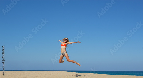 Woman tourist jumping on the beach and watching the landing planes at Island Phuket in Thailand. Hot beach Mai Khao.