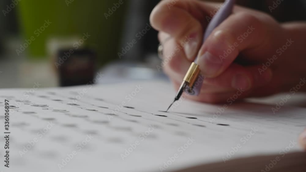a girl fills a calligraphy notebook with beautiful symbols a girl fills a calligraphy notebook with beautiful symbols