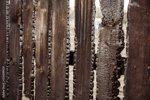 Burnt fence boards after a fire in a private house. © YouraPechkin