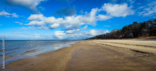 Sandy Jurmala Coastline under Cloudy Blue Sky, Latvia photo