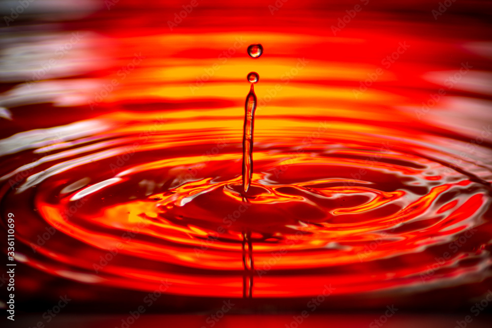Wasser tropfen auf wasser rot Hintergrund beleuchtung mit kleinen wellen 