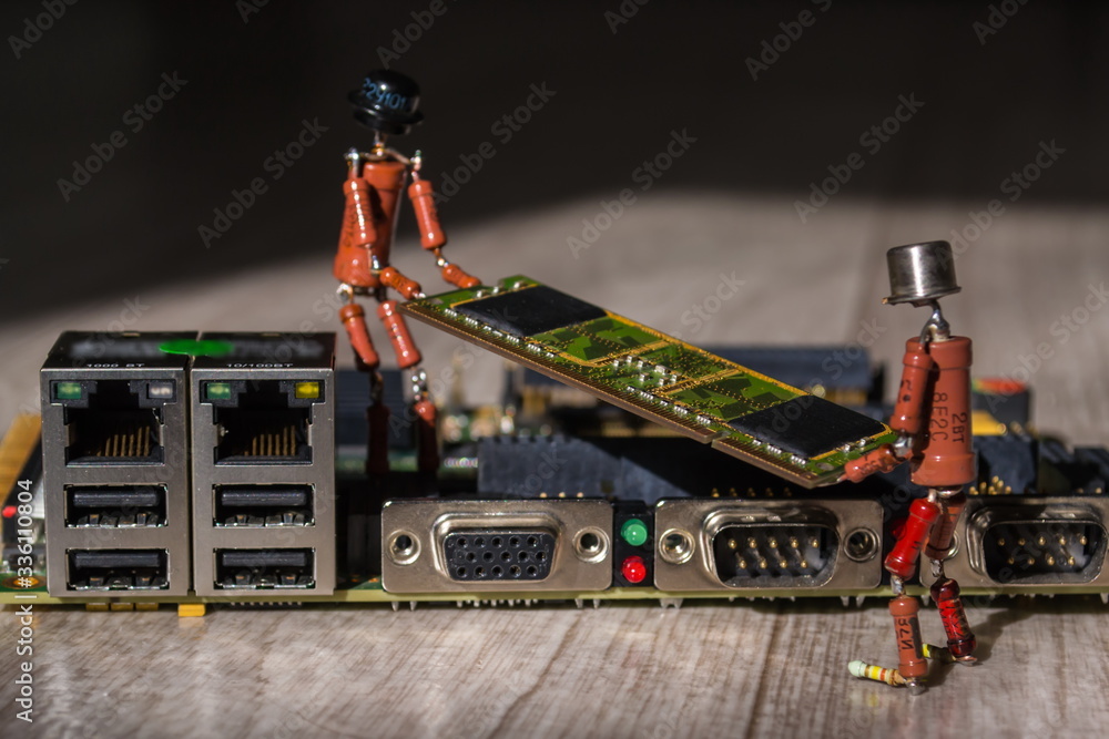 two small handmade human figures from resistors help to install SODIMM memory module to modern rugged embedded computer board