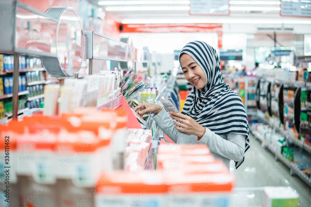 muslim asian woman shopping in grocery store supermarket buying some product