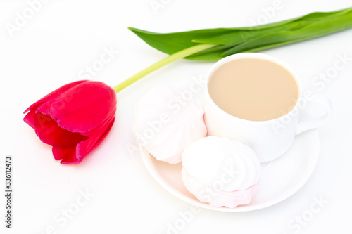 marshmallows, tea or coffee with milk and a tulip flower. on a light background. delicate breakfast, breakfast in bed. for the beloved. Surprise.
