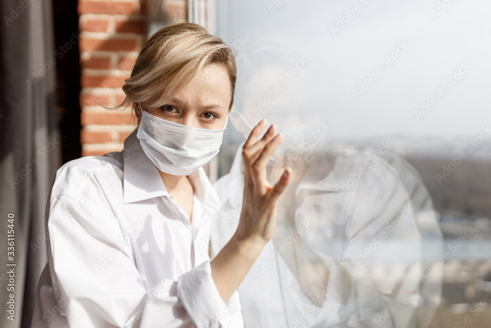 Illness girl on home quarantine. Girl in protective medical masks sits on windowsill and looks out window. Virus protection, coronavirus pandemic, prevention epidemic. Illness girl on home quarantine. Girl in protective medical masks sits on windowsill and looks out window. Virus protection, coronavirus pandemic, prevention epidemic.