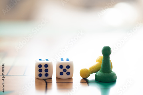 Colorful, bright game chips stand on a game Board with playing cubes: the concept of Board games, the background, games at home, a place for text