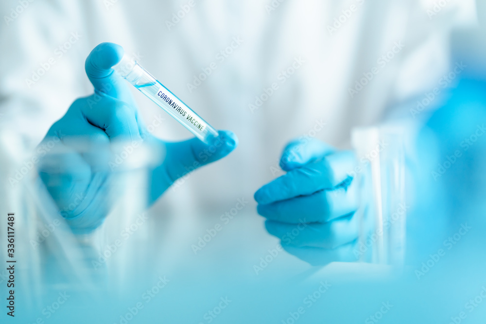 scientist holding test tube with covid-19 or coronavirus vaccine label, lab testing for inventing pandemic medication scientist holding test tube with covid-19 or coronavirus vaccine label, lab testing for inventing pandemic medication
