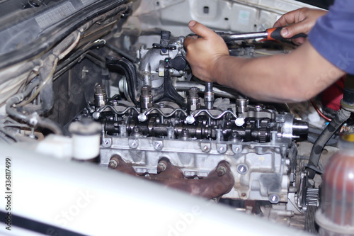 The mechanic is checking the engine.