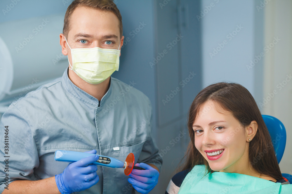 The girl is sitting in a chair at the dentist's appointment. Dental treatment. The dentist examines the patient's teeth. Teeth checkup at dentist's office.