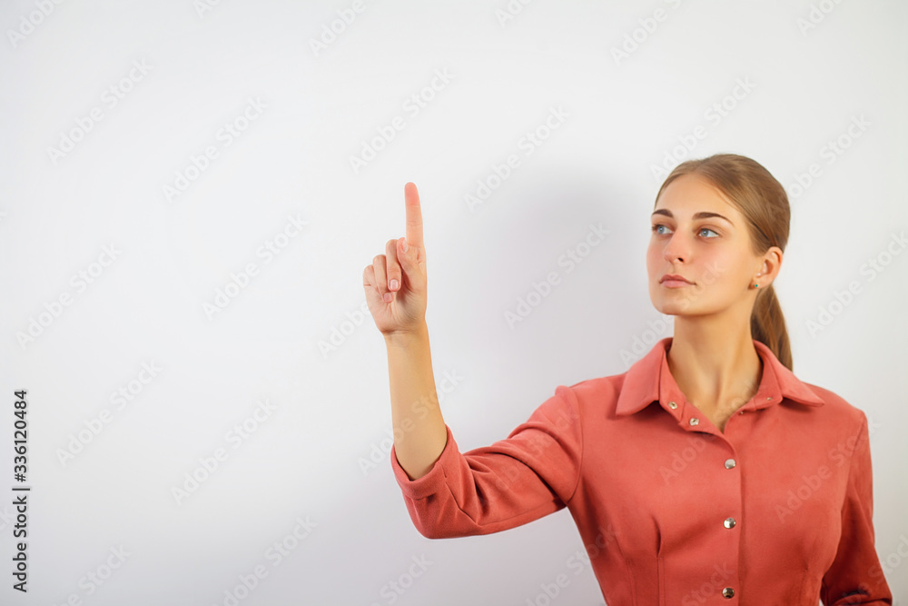 Woman touching an imaginary screen with her finger.Portrait of female college student touching something on copy space.Attractive young woman touching a virtual interface with her finger Woman touching an imaginary screen with her finger.Portrait of female college student touching something on copy space.Attractive young woman touching a virtual interface with her finger