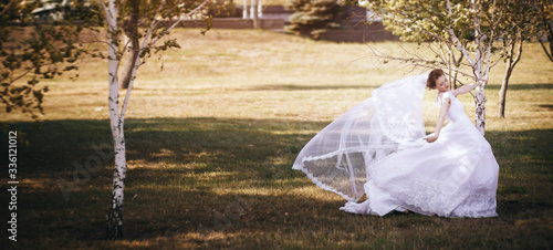 Happy bride on wedding day. Walk the bride in the national park in autumn. Beautiful wedding. Widescreen photo.