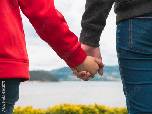 close up look of a girl and a boy holding hands, family love and care concept