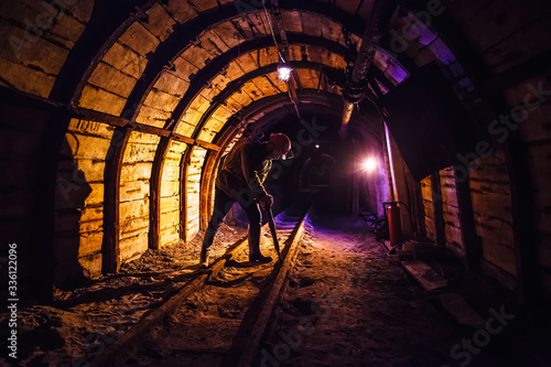 Miner working a jackhammer in a coal mine. Work in a coal mine. Portrait of a miner. Copy space.