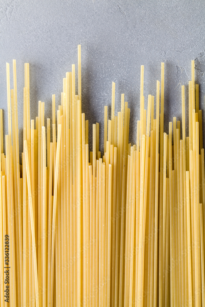 Yellow long spaghetti on blue background. Raw spaghetti bolognese. Yellow long spaghetti on blue background. Raw spaghetti bolognese.