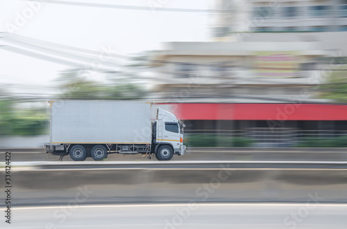 Motion image of the white truck driving on the road with speed.