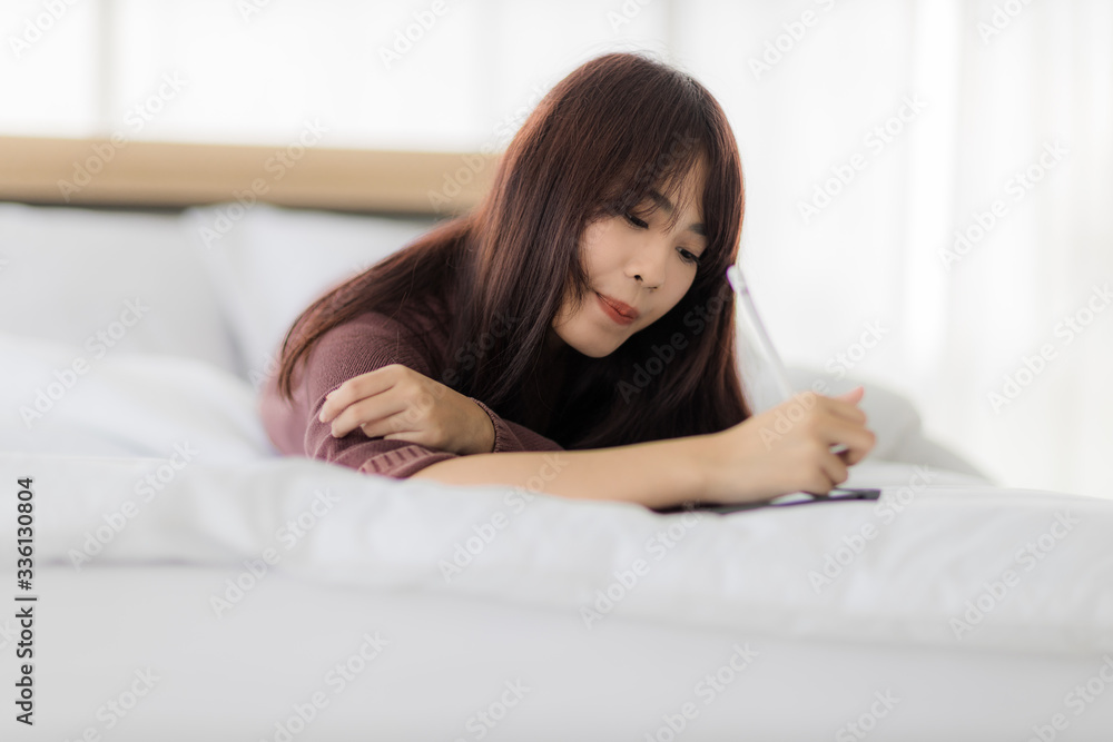 Asian woman using tablet for working, educational, e-commerce, social media in her bed. corovavirus covid-19, stay at home, work form home concept. Asian woman using tablet for working, educational, e-commerce, social media in her bed. corovavirus covid-19, stay at home, work form home concept.