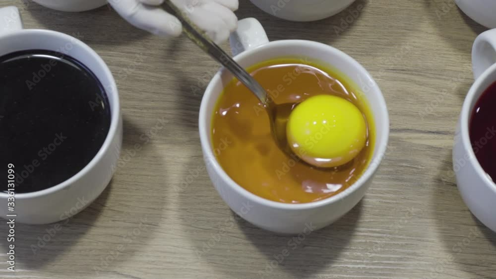 Easter eggs dyeing, dipping in yellow color. Simple holiday decoration technique Easter eggs dyeing, dipping in yellow color. Simple holiday decoration technique