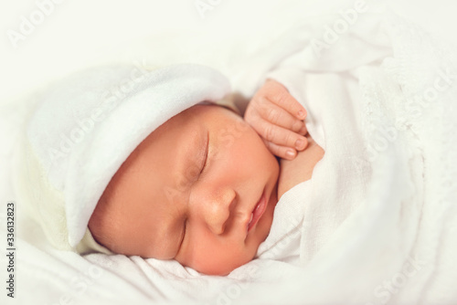 Close up of cute newborn baby taking nap on white lace sheets. Sweet child resting in shelf in the dresser. Concept of sleeping infant.