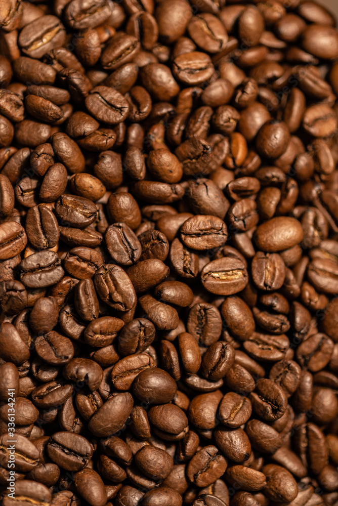 Grains of fresh roasted coffee close-up against a dark background. Coffee beans texture