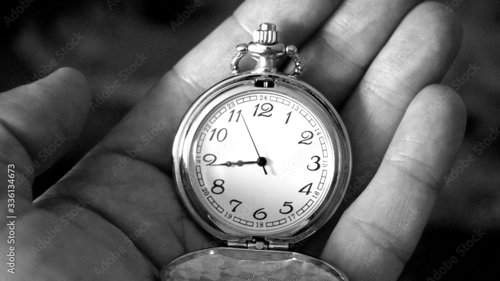Old antique pocket watch showing time being held in hand. Close up black and white photography Old antique pocket watch showing time being held in hand. Close up black and white photography