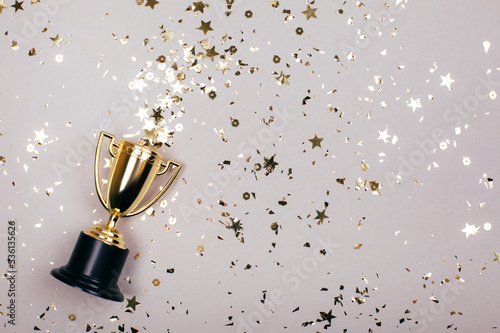 Sparkles grey background with a winners cup. Flat lay style. photo
