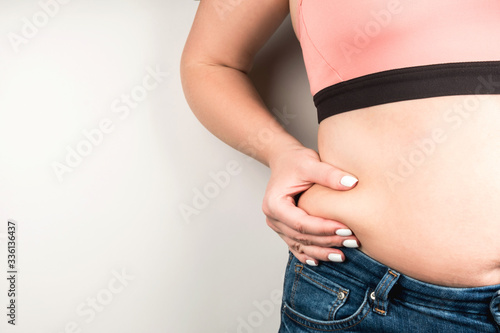 Overweight woman in jeans shows a crease © NS