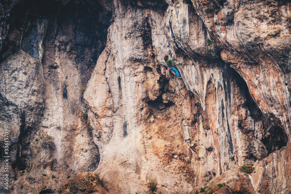 Obraz premium Girl climbs a rock.