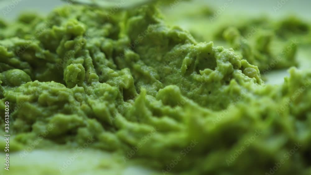Close up of making mashed avocado with fork for guacamole or bruschetta Close up of making mashed avocado with fork for guacamole or bruschetta
