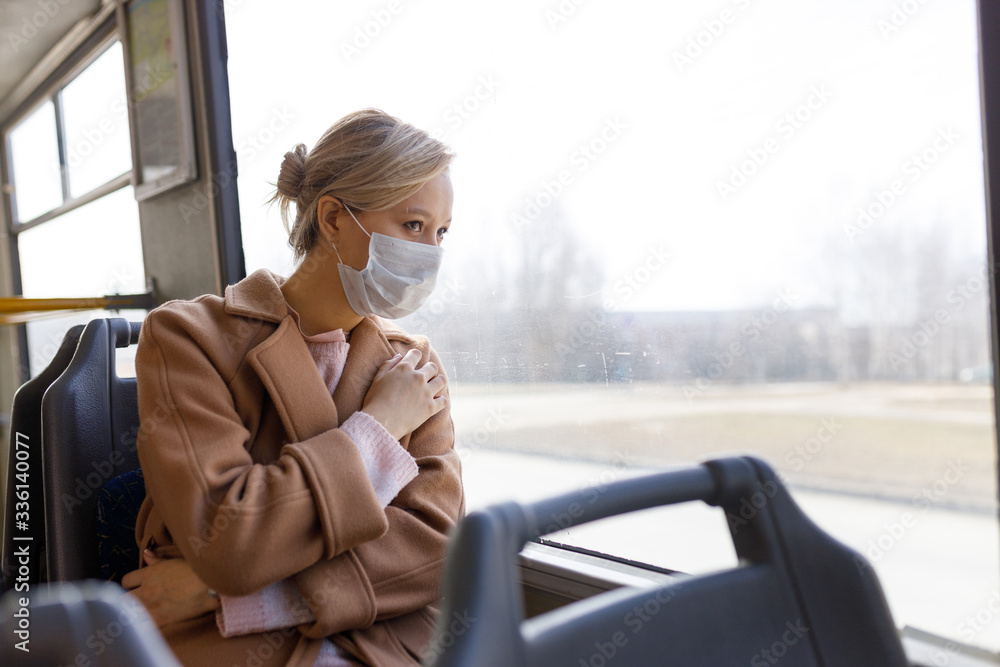 Girl in a protective mask rides on a bus. Virus protection, coronavirus pandemic, prevention epidemic.