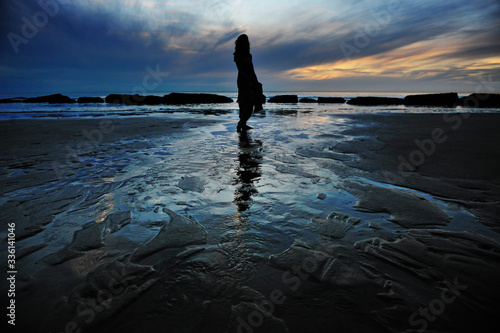 Silhouette of a woman walking on the beach