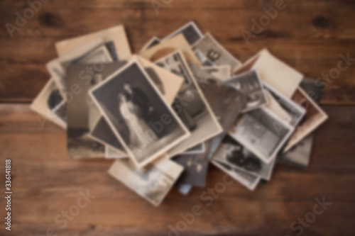 old vintage monochrome photographs in sepia color are scattered on a wooden table, the concept of genealogy, the memory of ancestors, family ties, memories of childhood photo