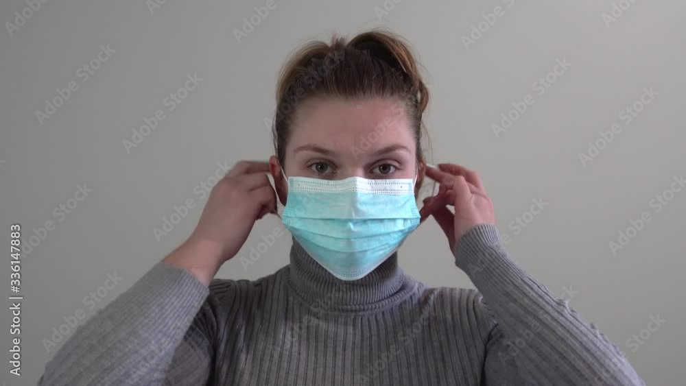 girl removes a sterile gauze mask from her face.
girl removes a sterile gauze mask from her face.