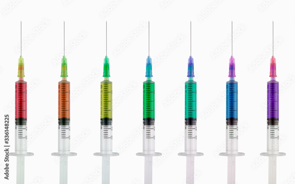 Syringes with multi-colored liquid on a white isolated background. Syringes of all colors of the rainbow. Syringes with multi-colored liquid on a white isolated background. Syringes of all colors of the rainbow.