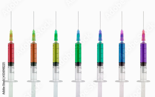 Syringes with multi-colored liquid on a white isolated background. Syringes of all colors of the rainbow.