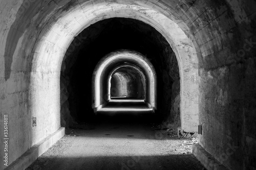 Grayscale shot of an arched concrete tunnel in Luan, Corbeyrier, Switzerland photo