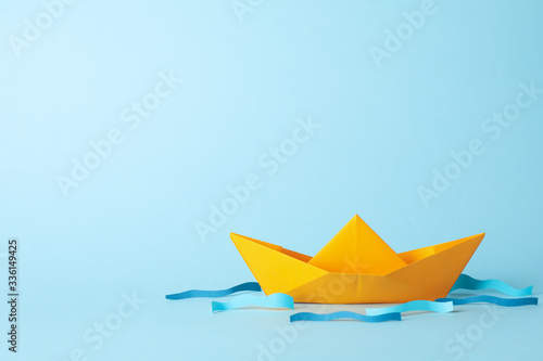 Paper boat and waves on blue background, space for text