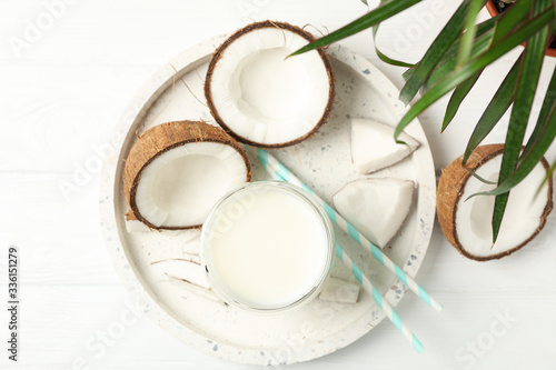 Tray with coconut and milk on wooden background, top view