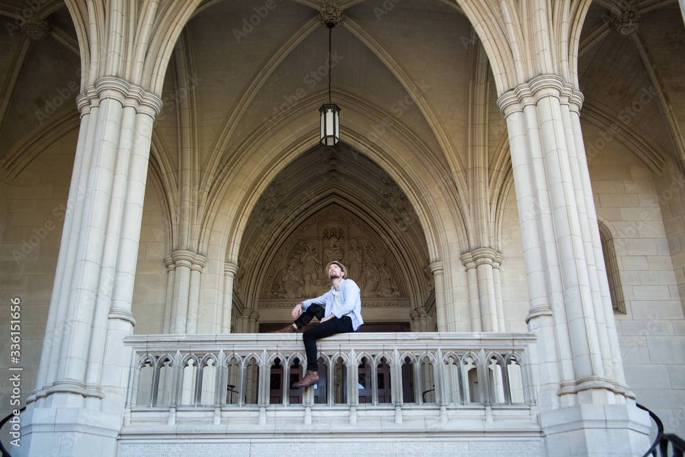 Young Hipster Man sitting outside cathedral in Europe