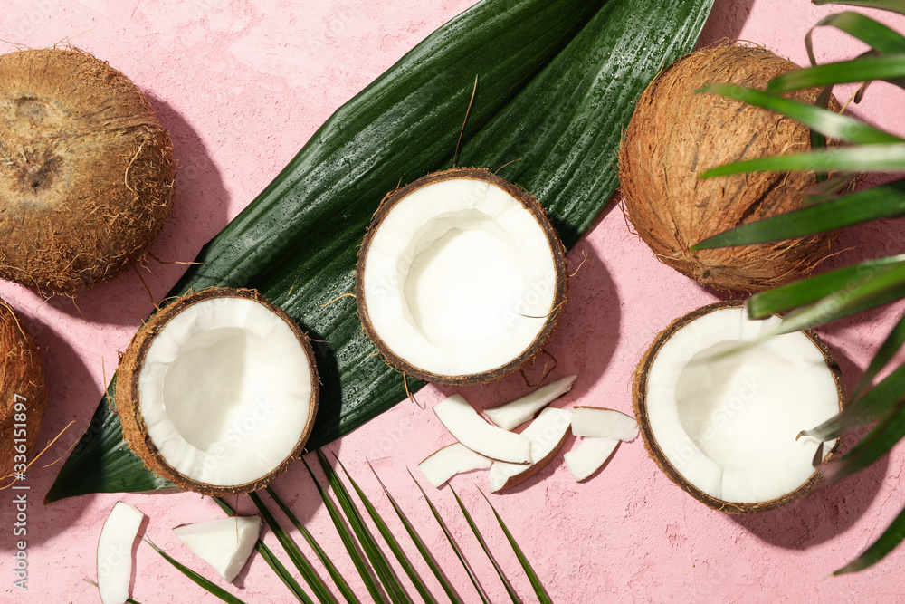 Coconut and palm leaves on pink background, top view Coconut and palm leaves on pink background, top view