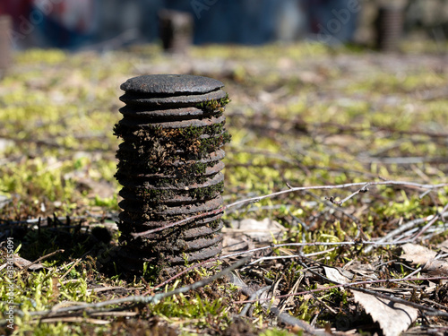 Old rusty bolts in the concrete base are overgrown with moss