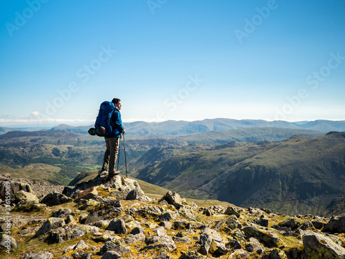 A hiker views the horizon from Great Gable, a mountain in the Lake District, Cumbria, England. photo