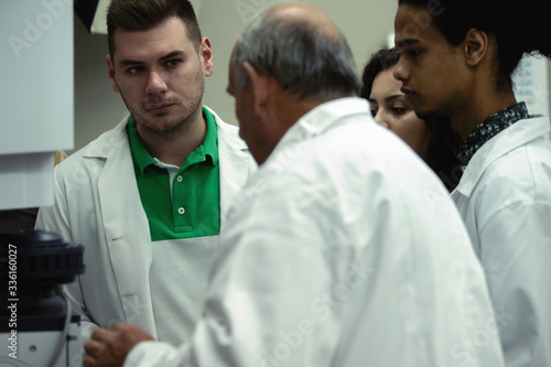 Laboratory scientist students working with profesor at lab 