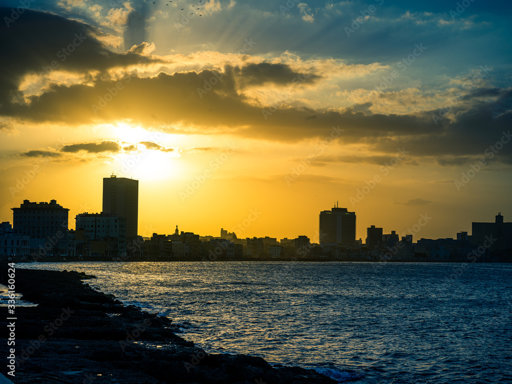 City silhouette in sunset by the sea at the Malecon, Havana, Cuba