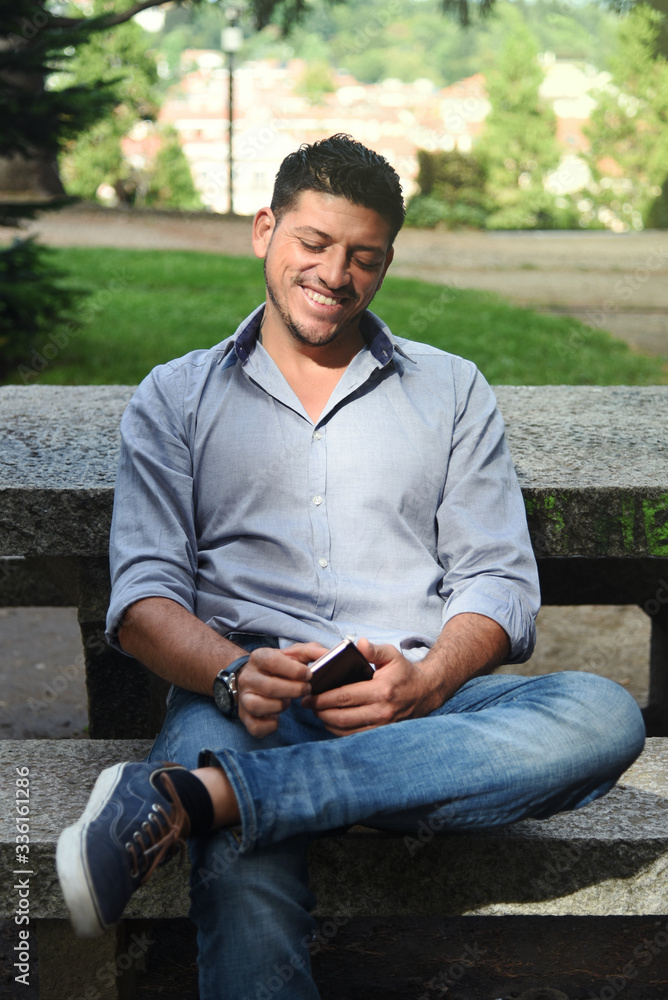 Obraz premium Handsome Guy with his Phone in a Park