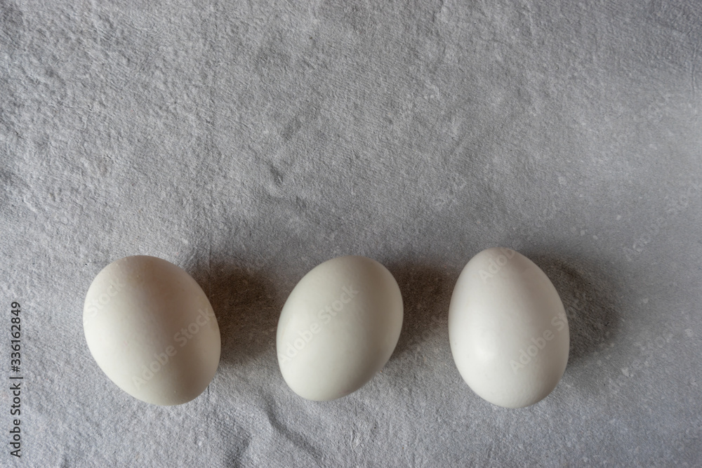 White eggs on paper background, copy space. White eggs on paper background, copy space.