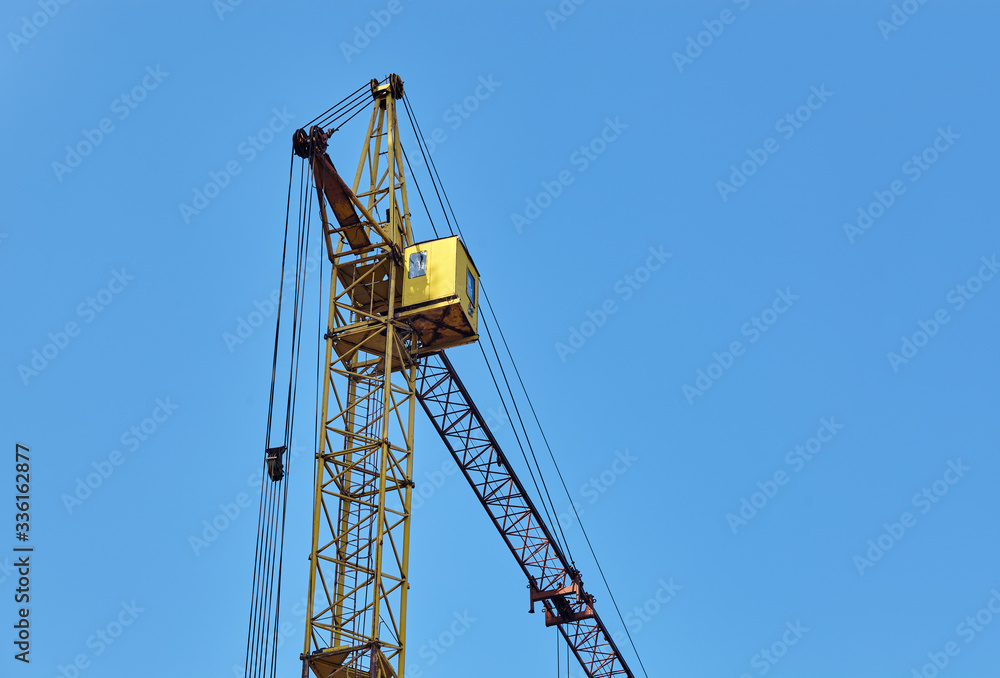 Tower crane building a house against sky Tower crane building a house against sky
