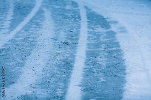 Snow asphalt. Car tracks on a snowy road in winter.