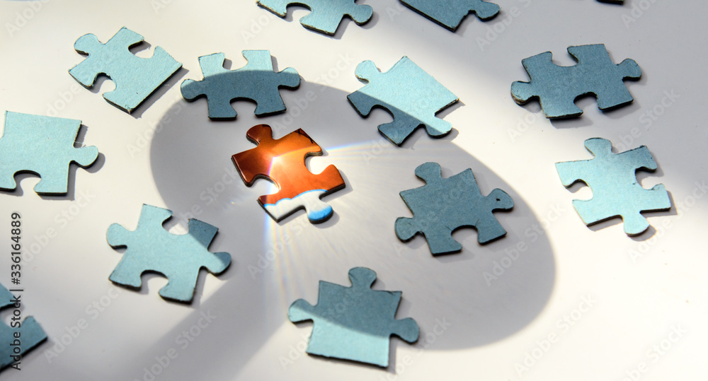 On a white background puzzles inside out. One red puzzle with a bright light point in the middle. Concept - leader, lead, identification of coronovirus On a white background puzzles inside out. One red puzzle with a bright light point in the middle. Concept - leader, lead, identification of coronovirus