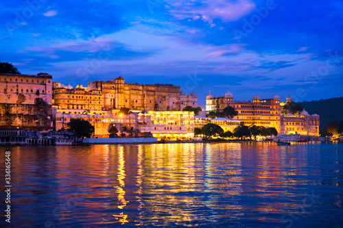 View of famous romantic luxury Rajasthan indian tourist landmark - Udaipur City Palace in the evening twilight with dramatic sky - panoramic view. Udaipur  India