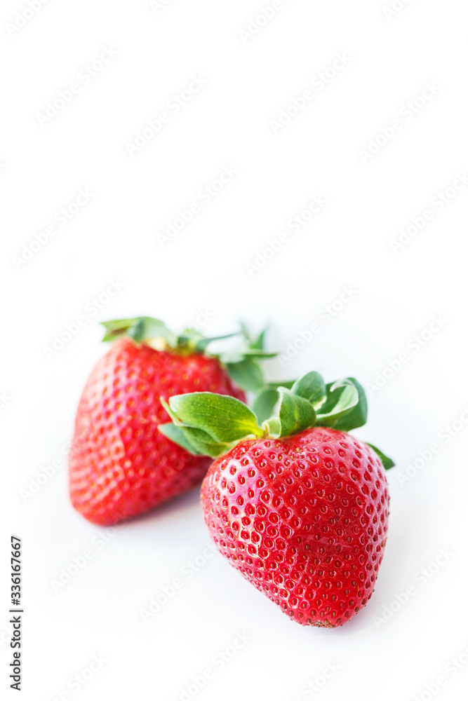 Two fresh strawberries were placed on a white background. Copy space Two fresh strawberries were placed on a white background. Copy space